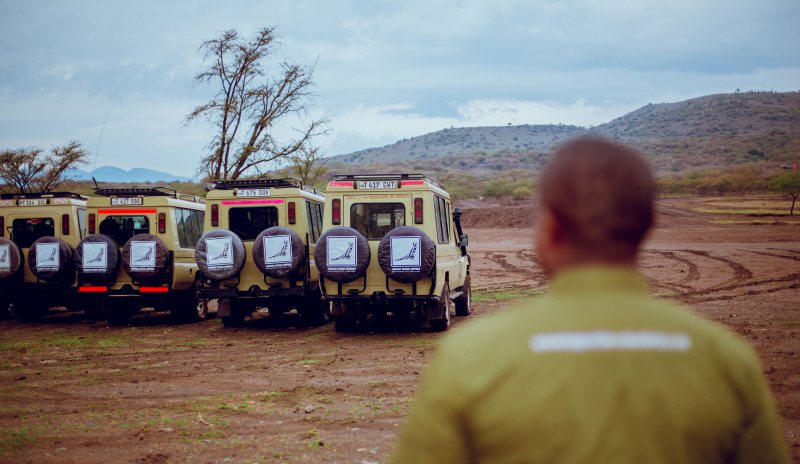 Guide looking out over the Lappet Faced Safaris fleet lined up in the bush