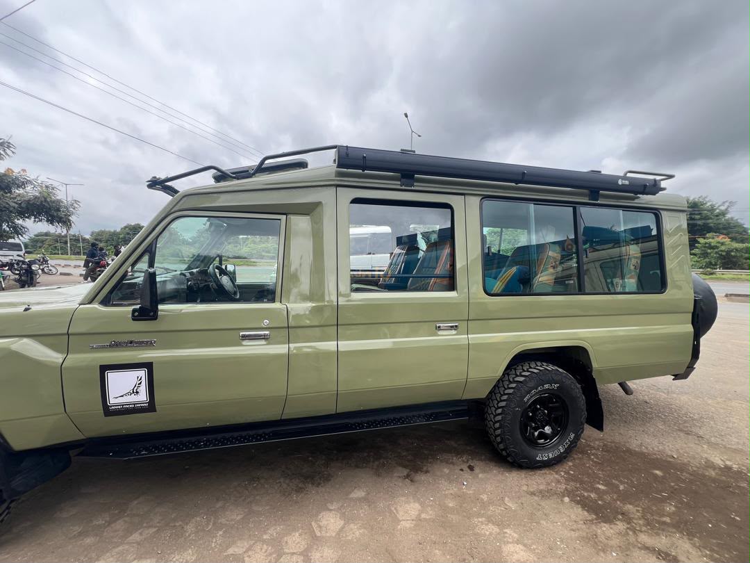Profile view of a green Lappet Faced Safaris safari Land Cruiser