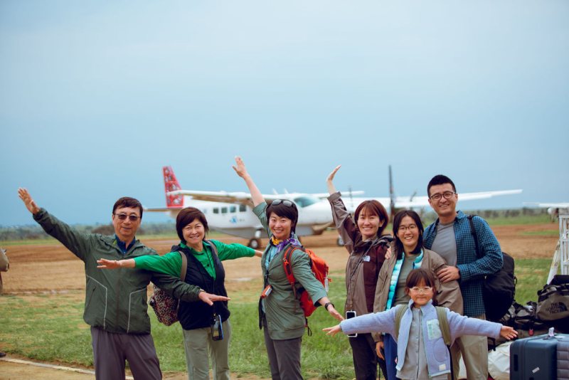 Guests celebrating beside a light aircraft at a bush airstrip