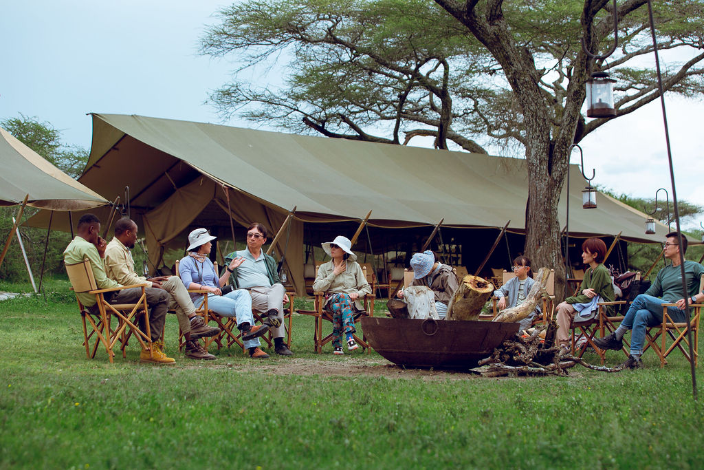 Guests sitting together under the open mess tent at camp