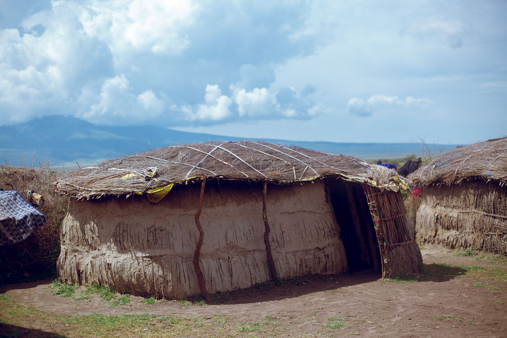 Maasai homestead hut with a mountain rising behind it