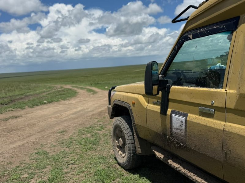 Mud-splashed safari Land Cruiser on a rough track