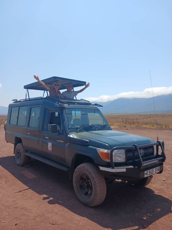 Safari vehicle with the crater rim rising behind